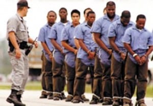 black men shackled and led by a white prison guard