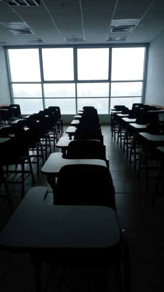 dark classroom with rows of desk chairs