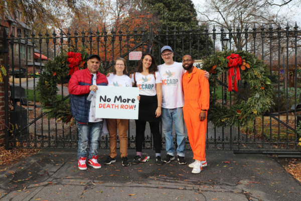 A group of people outside of Gov. Cooper's house with a "No More Death Row" sign